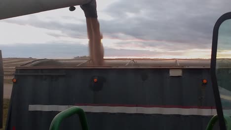 cosechadora verde descargando trigo en un camión