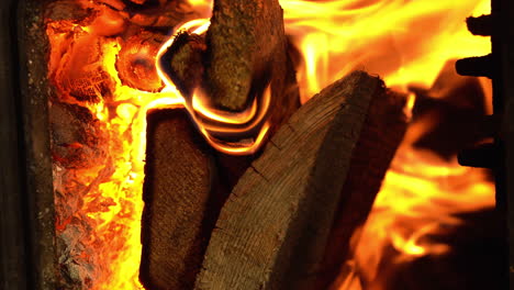 flames and firewood burning inside the stove, heating season, vertical shot