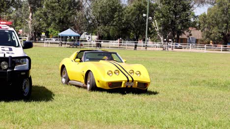 vintage sports car driving across field