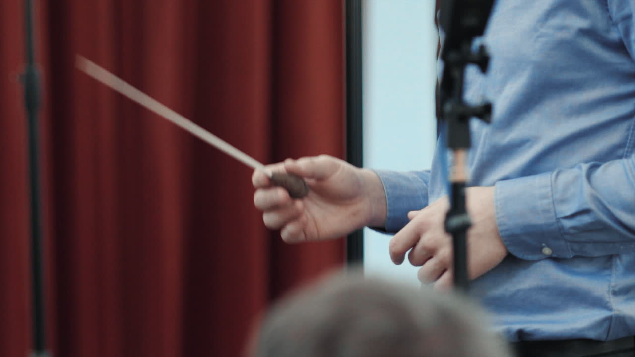 지휘자가 지휘봉을 흔들었다