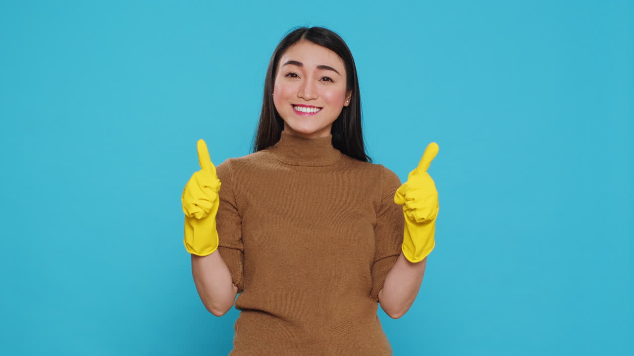 Positive joyful maid smiling while doing ok gesture after finishing to clean client house
