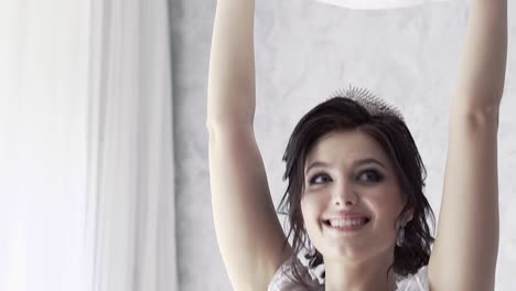 closeup-young-pretty-woman-tosses-satin-pillow-smiling