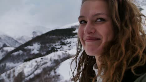 slow motion view of woman smiling at the camera whilst walking in the mountains