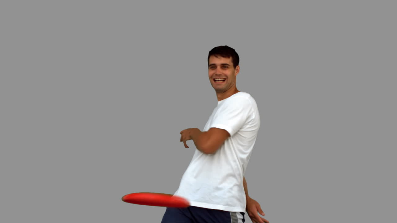 Man throwing a frisbee on grey screen