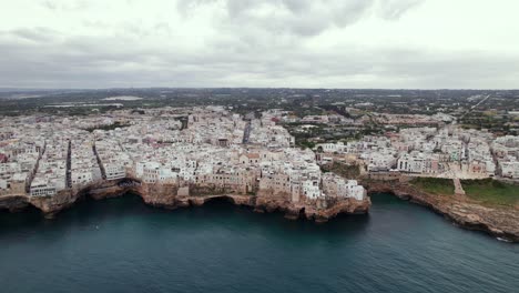 Vista-Aérea-De-La-Ciudad-Italiana-De-Polignano-En-La-Costa-Rocosa-Del-Mar-En-Puglia,-Italia