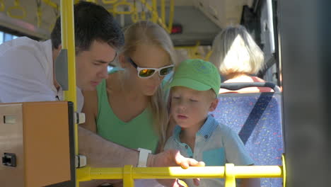 son and mother using dads smartwatch in the bus