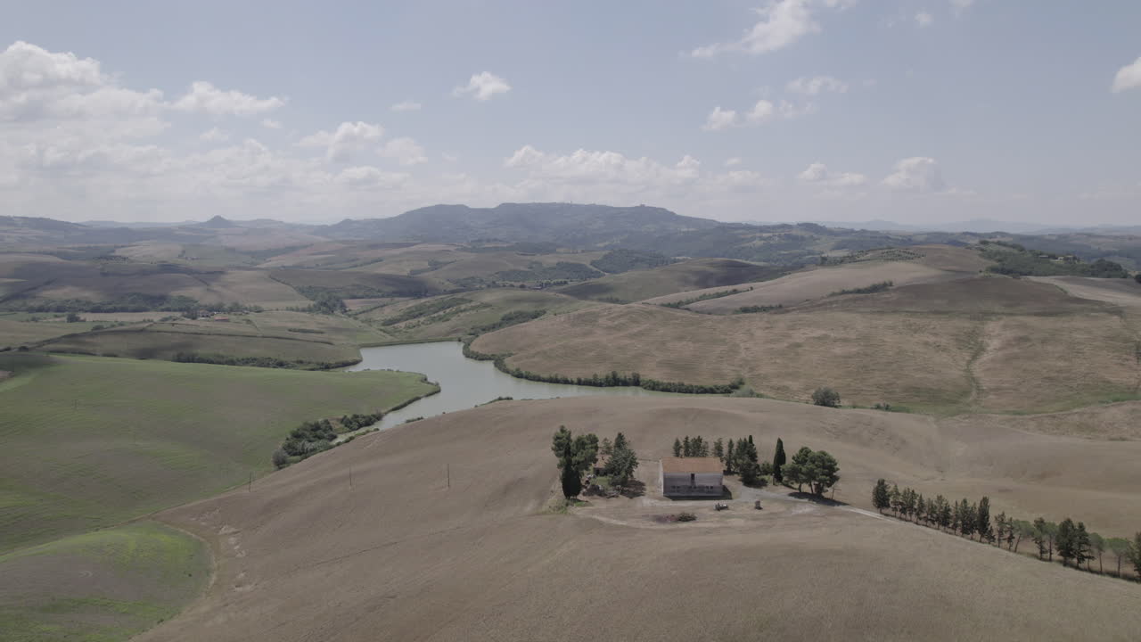토스카니 (이탈리아) 의 휘어지는 도로와 황금색 농장 풍경의 드론  - 파란 하늘과 지평선에 구름이 있는 은 날의 풍경