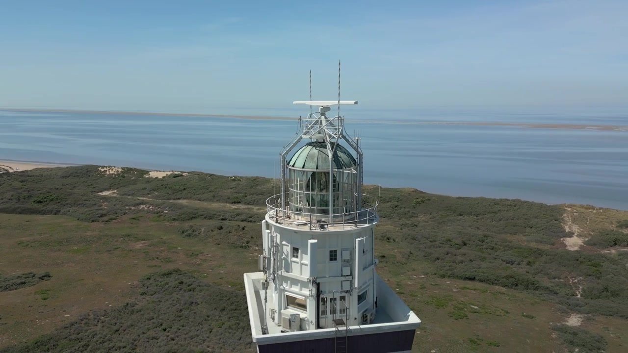 En drone cirkler toppen af Westhoofd fyrtårnet i Holland, et karakteristisk, firkantet tårn