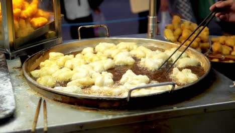 Frying-deep-fried-dough-stick-in-the-pan-at-Yaowarat-Road-Chinatown,-a-popular-travel-destination-in-Bangkok,-Thailand