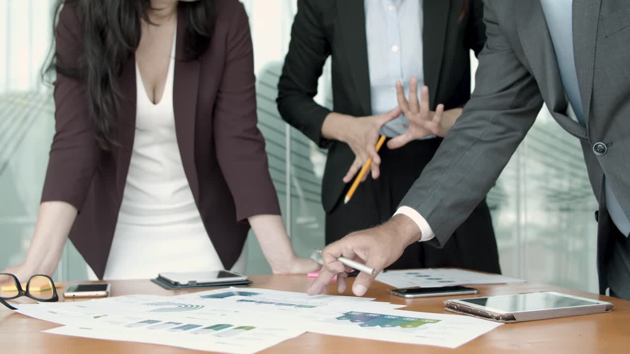 비즈니스 팀이 종이 보고서를 분석합니다.