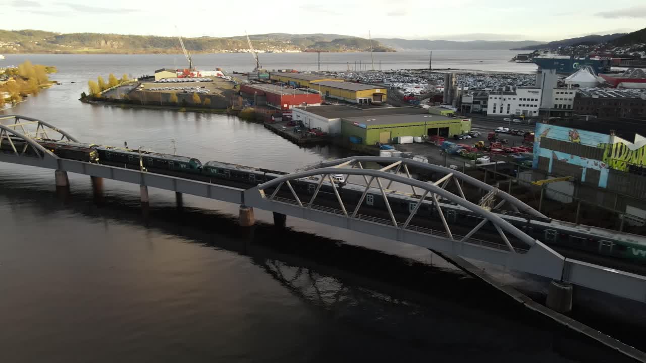 trenes que se cruzan en el puente sobre el río drammenselva cerca del puerto en drammen, noruega