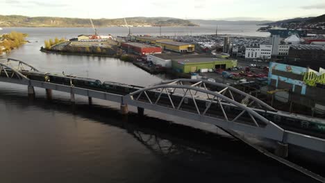 Trains-crossing-each-other-on-the-bridge-over-the-river-Drammenselva-near-the-harbor-in-Drammen,-Norway