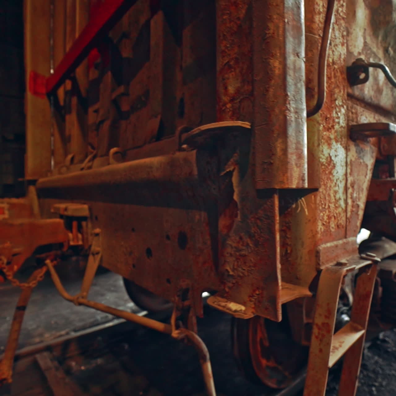 Old and rusty container leaves on the rails from the tunnel on the territory of the railway. Close-up. View of bottom.