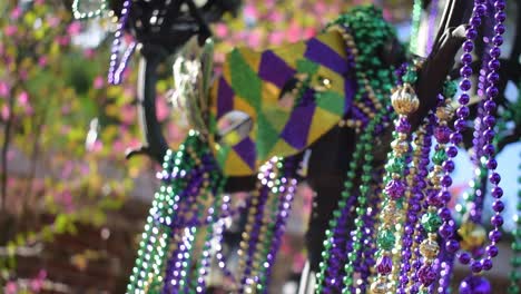 outdoor mardi gras beads and mask on light post in sunshine