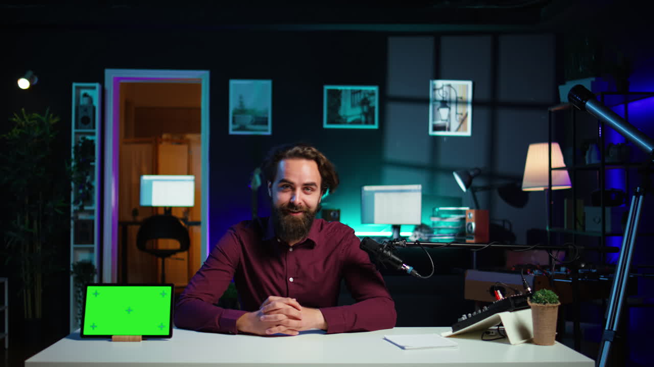 hombre revisando el dispositivo digital de pantalla verde, grabando con equipos especializados