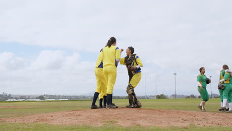 multiracial female baseball players and male umpire celebrating and shaking hands on a pitch