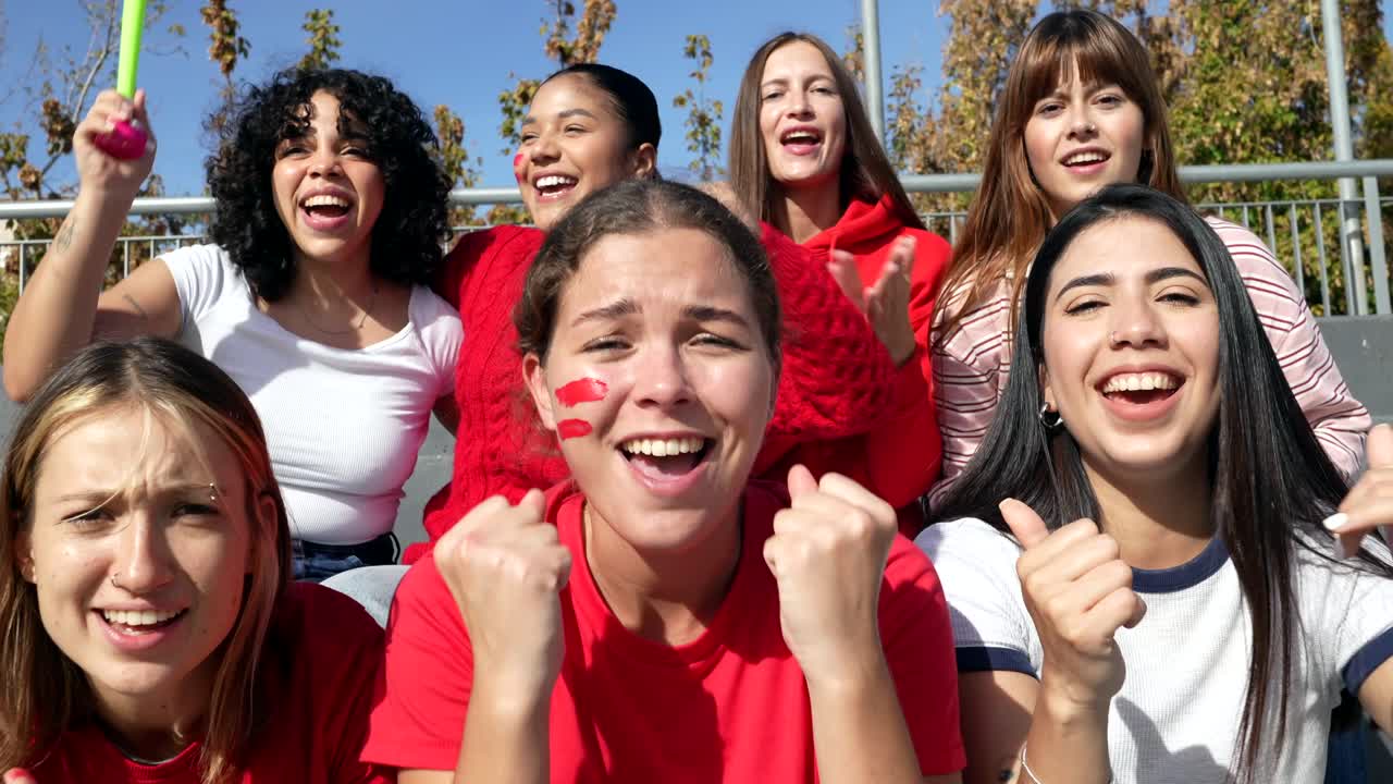 Group of excited women cheering for their team in a stadium