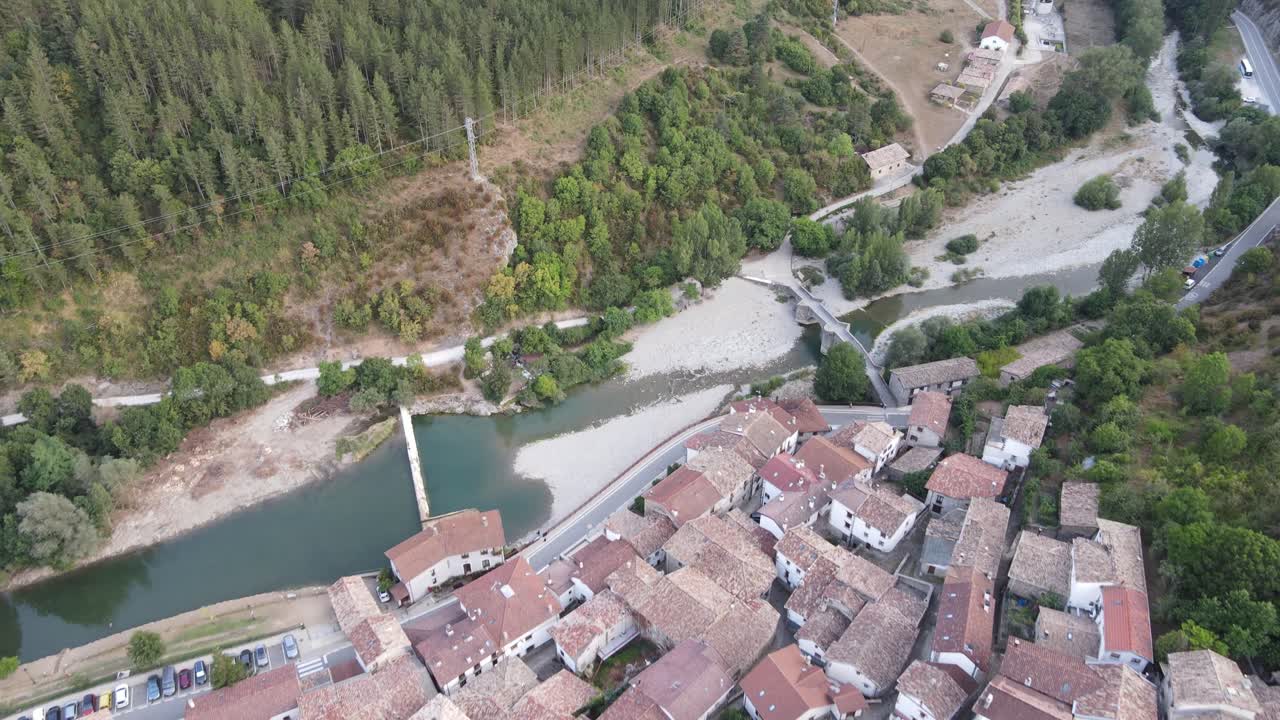 Aerial view from drone looking down on pretty riverside town of Burgui, in Navarra, Spain while backing