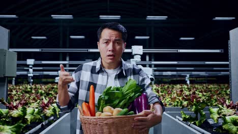 granjero masculino asiático con una canasta de verduras mostrando un gesto desconcertado y diciendo qué en la granja inteligente