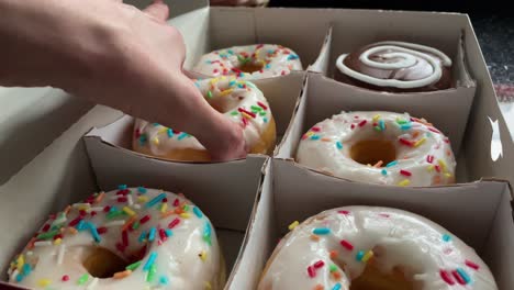 close-up camera movement of a girl picking donuts