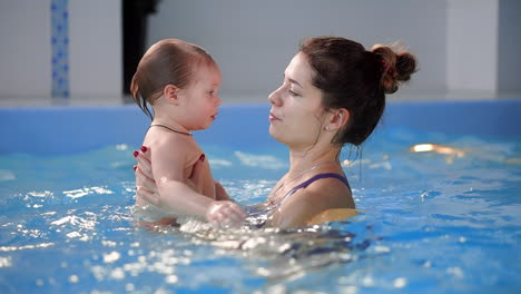 cute baby boy enjoying with his mother in the pool.