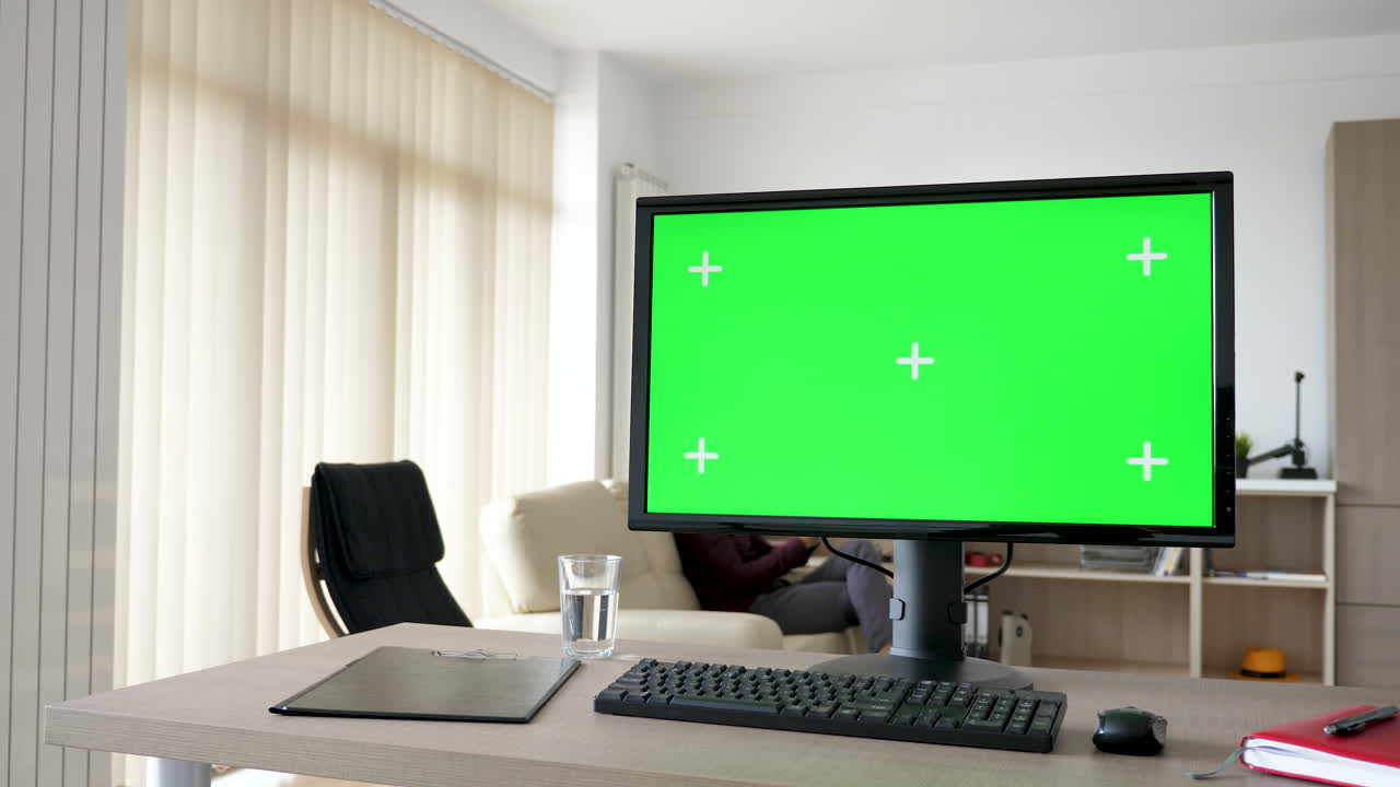 Images of a computer monitor with a green screen in an office setting