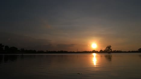 Die-Atmosphäre-Oder-Atmosphäre,-Wenn-Die-Sonne-Auf-Der-Oberfläche-Des-Sees-Untergeht,-Sonnenuntergang