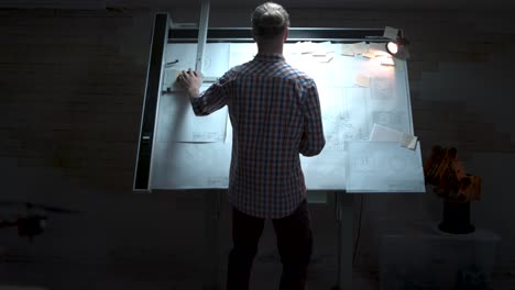 engineer working on blueprints in a design studio