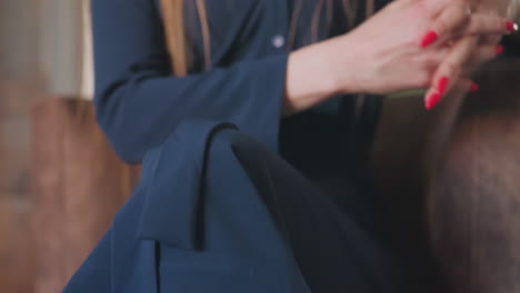 lower view of therapist in blue dress seated on round sofa with legs crossed, calmly engaging during session, with focus on posture and subtle body language in serene interior setting