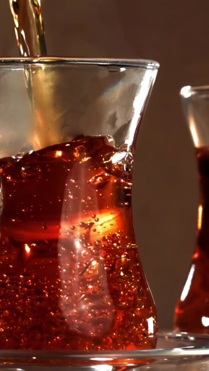 Primo piano di tè rosso versato in un bicchiere tradizionale