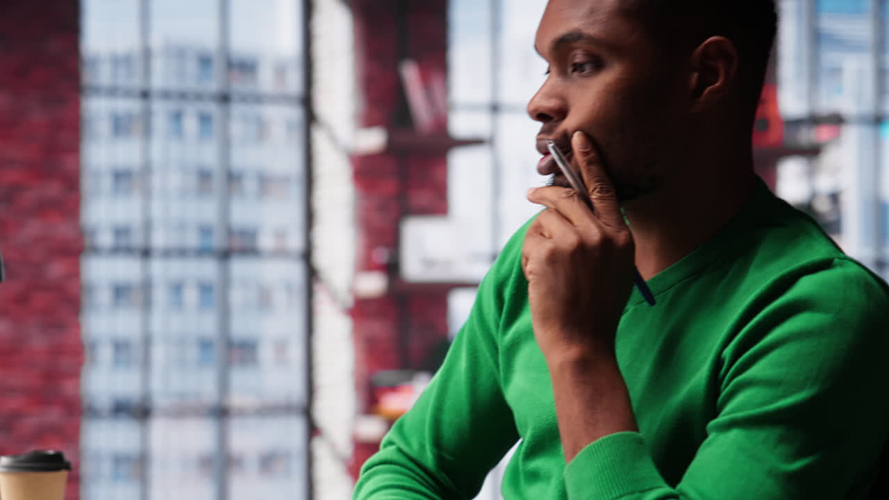 Vertical Video Young remote worker being pensive thinking about new ideas to make money