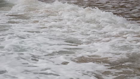 foamy waves crashing on the shore of con dao island, vietnam