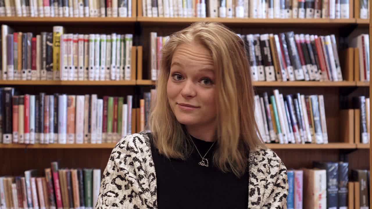 귀여운 소녀가 책을 닫고 마지막에 웃고 있습니다, 재미있는 순간