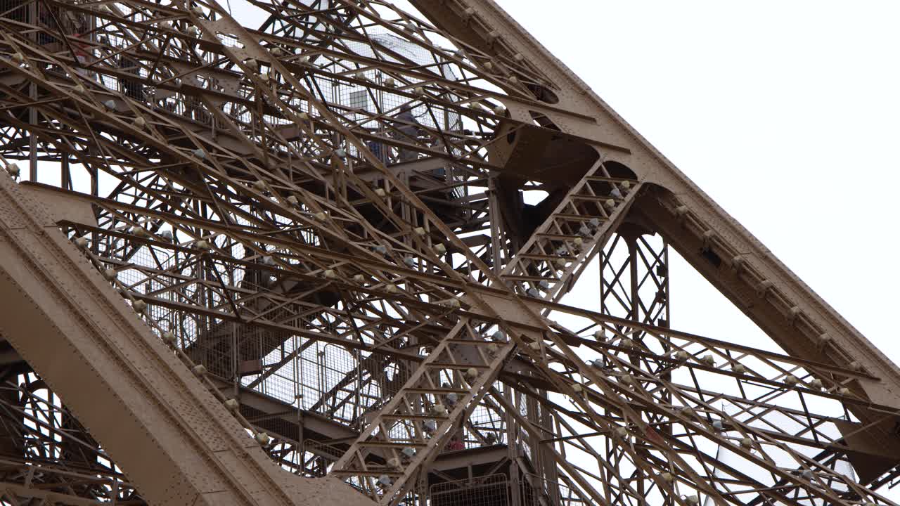 Static medium shot captures detailed metal beams and architectural engineering of a famous French monument