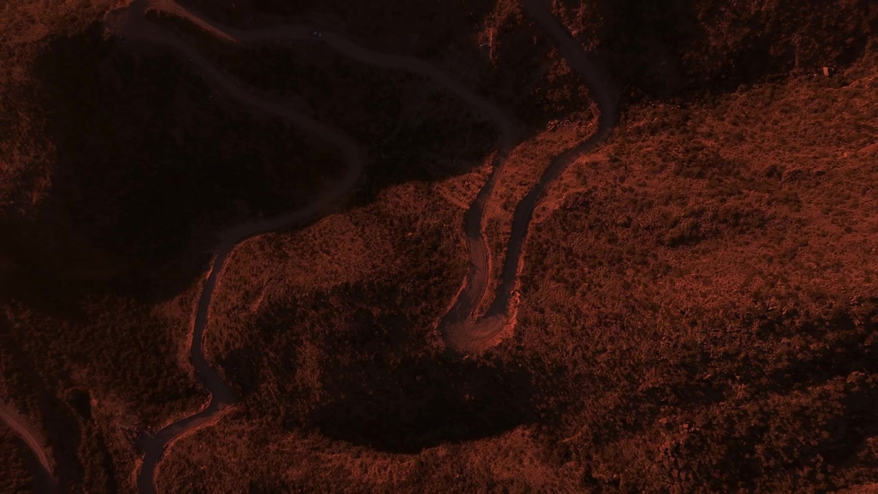 Ripresa aerea con drone dall'alto dell'alba all'ora d'oro nella valle tra le montagne rocciose in Argentina