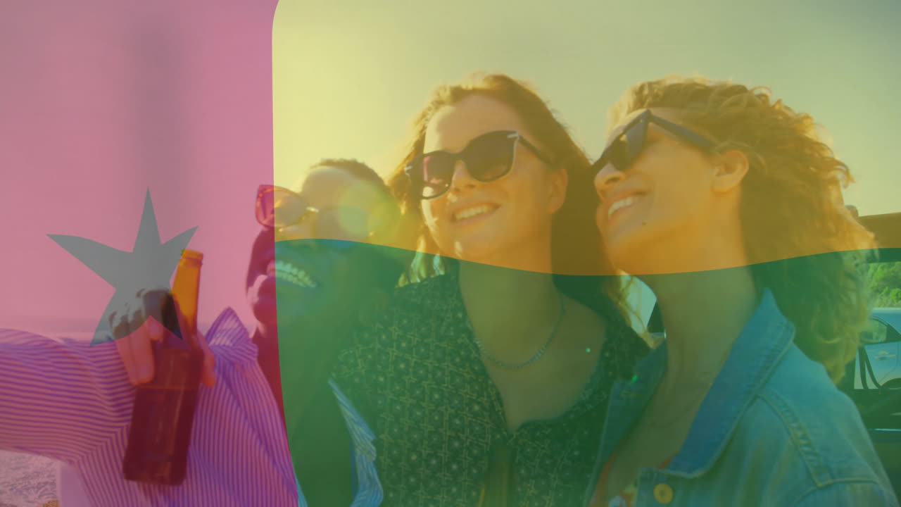 Watching sunset, friends on beach with Guinea-Bissau flag animation overlay