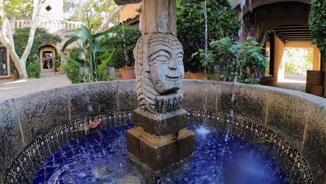 cámara lenta de agua salpicada en la lente de la cámara, desde una fuente hecha de piedra decorativa tallada en el pueblo de artes y compras de tlaquepaque, sedona, arizona