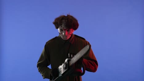 man in white mask with chainsaw in hands on blue background image of maniac jason voorhees from