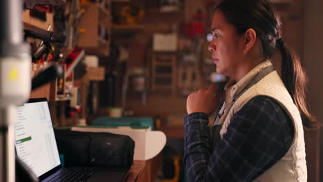 woman, workshop and carpenter with a laptop