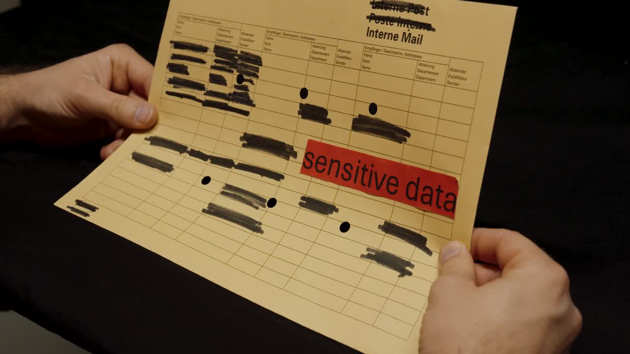 A close-up of a paper document marked “sensitive data” with multiple sections blacked out, symbolizing secure handling and protection of confidential information