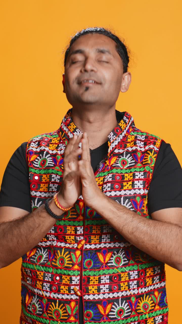 Indian Man Praying with Hands Together in Traditional Embroidered Vest