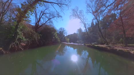 vuelo otoñal de drones fpv sobre un río, cascada y bosque con luz solar gloriosa