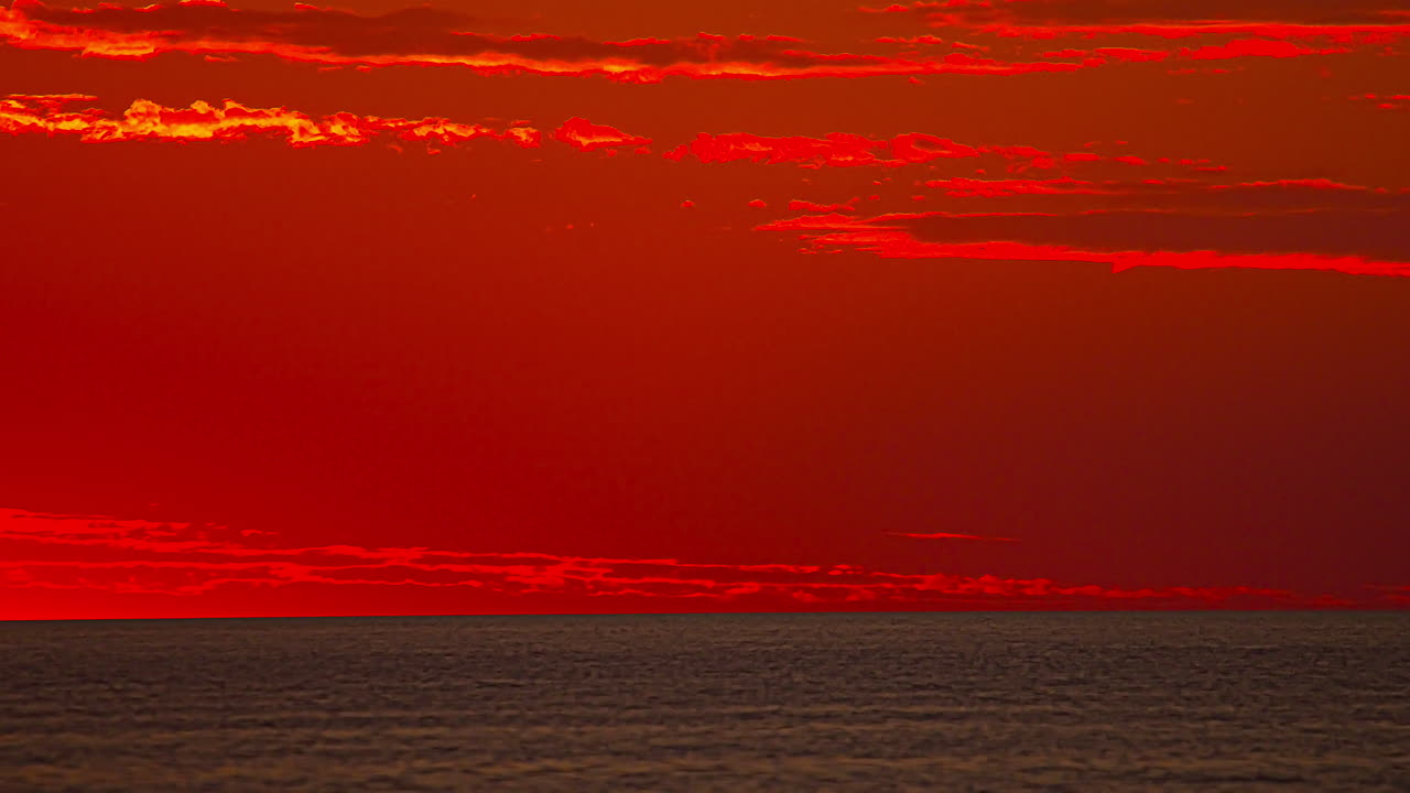 붉은 불 같은 하늘 배경, 시간 경과에 수평선에 떠오르는 반원 태양