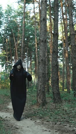 evil ghost hooded creature walking across forest. halloween. vertical video