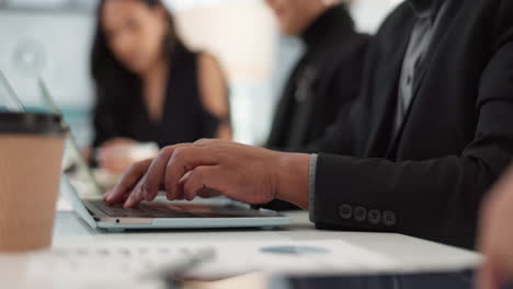 manos de un hombre en una reunión en la oficina con una computadora portátil