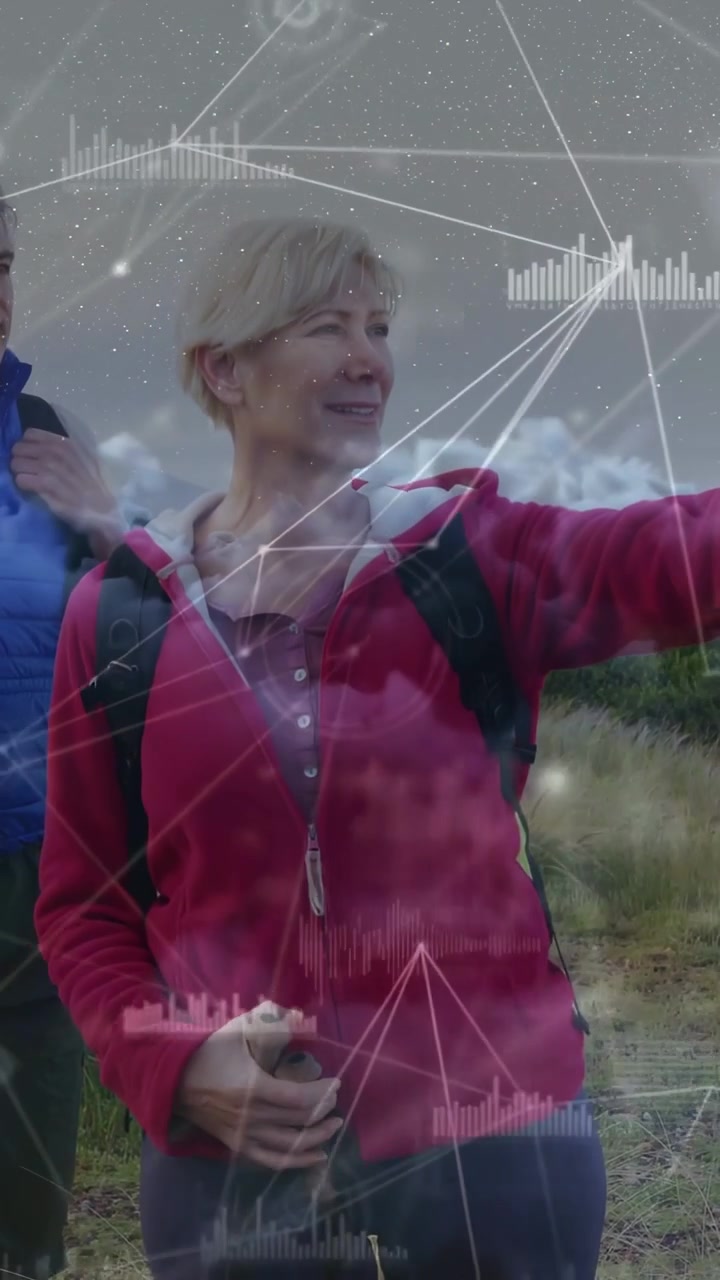 Video verticale: Donna che alza il braccio indicando un percorso su un sentiero erboso, HUD tecnologico che corrisponde al gesto.