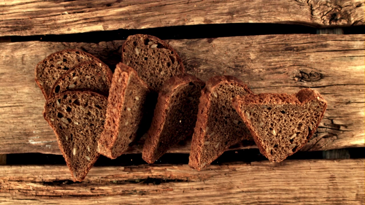 Slow Motion Rack Focus on Sliced Rye Bread with Seeds on Wood