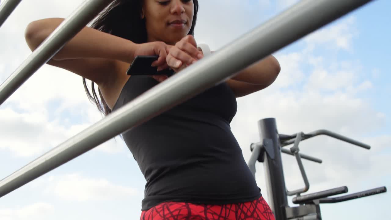 mujer discapacitada usando un reloj inteligente en el parque 4k