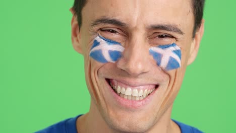 man with a scottish flag painted on the face smiling