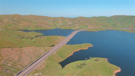 state route 152 on san luis reservoir surrounded with lush green hills in california, usa